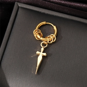 Macro view of gold cross dagger pendant on polished stainless steel hoop earring