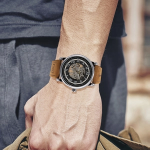 Macro shot of silver skeleton mechanical watch with roman numerals and brown leather strap