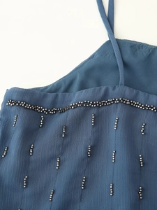 Close-up of blue beaded strap top featuring intricate sequin texture and delicate details