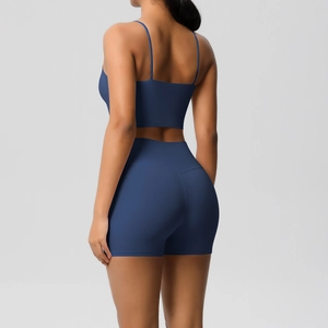 Detail view of indigo yoga set featuring cross-back straps and high-waist fitness shorts