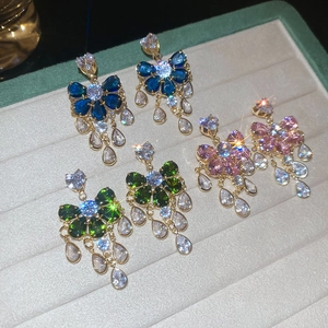 Detail view of sparkling flower tassel earrings in blue, green, and pink zircon finishes