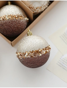 Close-up of 8cm champagne and brown Christmas balls with glitter and bead embroidery