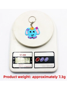 Blue elephant PVC keychain on an electronic scale showing product weight of 7.3g