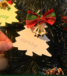 Macro detail of Christmas tree plaster ornament with red plaid bow and golden bells