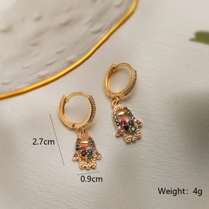 Detailansicht der Hamsa-Ohrringe in Gold mit bunten Zirkoniasteinen und Maßangaben auf Seide