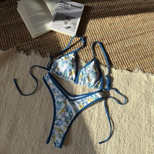 Floral print two-piece bikini set with blue contrast trim and tie-side bottoms