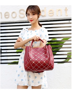 Détail du grand sac cabas bordeaux avec coutures en losanges et rivets perlés