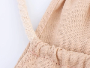 Détail de la texture en lin de la robe avec cordon de serrage en corde tressée et couture