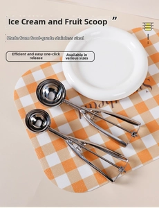 Close-up of dual stainless steel ice cream scoops with mechanical trigger on a table