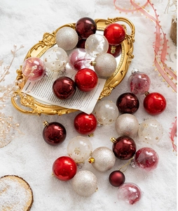 Detailed view of assorted Christmas ball ornaments in red and gold on a snow tray