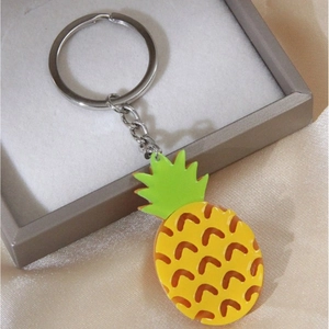 Porte-clés ananas jaune doux avec anneau en métal sur fond de soie élégante