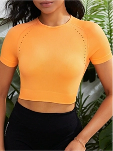 Detail des orangefarbenen Yoga-Tops mit Belüftungsöffnungen und Rippstrick-Textur