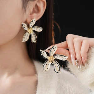 Vintage floral stud earrings featuring black polka dots on cream enamel with gold accents