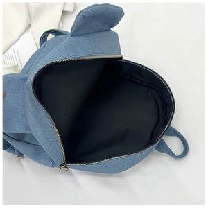 Detail view of the open blue denim backpack with cute ear accents and metal zipper
