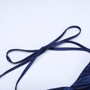 Gros plan du nœud élégant en satin bleu marine et texture soyeuse sur la robe