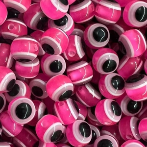 Detailed view of stacked hot pink resin evil eye beads for DIY jewelry making