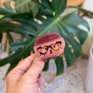 Detail of pink acetate hair claw clip featuring a cute cartoon dog face with glasses