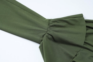 Détail macro du poignet de manche vert armée avec bordure à volants et texture tricotée