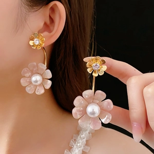 Detail of pink resin flower earrings with white pearl and sparkling zircon crystal studs
