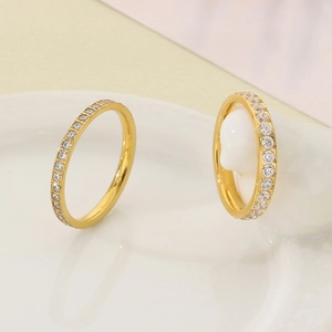 Macro view of two gold-plated stainless steel eternity rings with white cubic zirconia