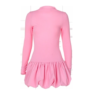 Détail de la robe rose à manches longues montrant la coupe ajustée et l'ourlet plissé