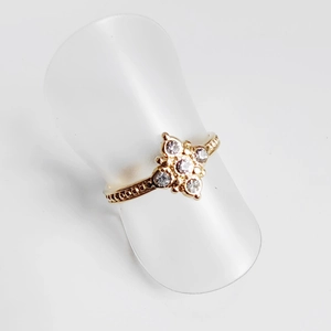 Macro detail of 18K gold plated ring with cross-shaped flower cluster and cubic zirconia