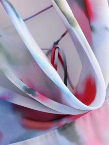 Detailed close-up of colorful tie-dye chiffon fabric with elegant draped texture
