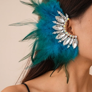 Detail of luxury bohemian crystal ear cuff featuring vibrant blue feather accents