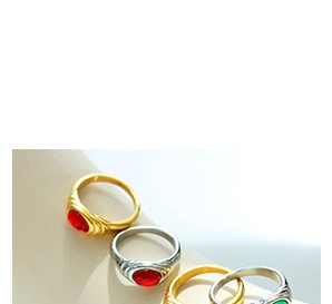 Detail of vintage textured rings featuring oval red and green gemstone pendants