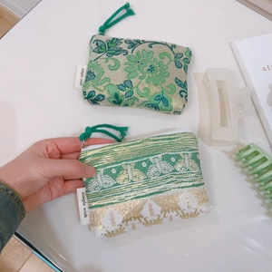 Detail of jacquard fabric mini purses with floral patterns and braided zipper pulls