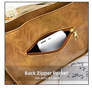 Detail view of the brown vintage tote bag showing the functional rear zipper hidden pocket