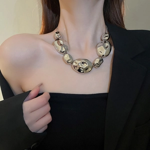 Close-up of a high-shine silver necklace featuring large irregular metallic beads