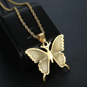 Close-up of golden stainless steel butterfly pendant with twisted rope chain on black texture
