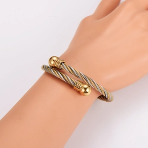 Retro stainless steel twisted cable bangle in gold and silver finish on model arm