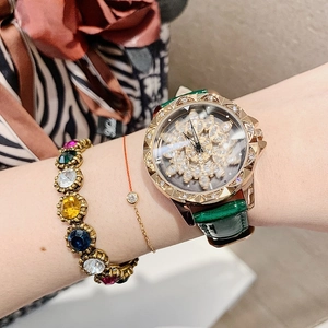 Close-up of luxury women's watch with flower dial and green leather strap on wrist