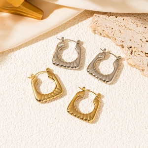 Detailed shot of gold and silver irregular square hoop earrings with textured metal finish