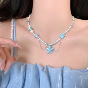 Detail of beaded necklace with starfish charms and silver tassels on model