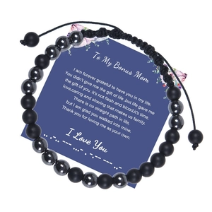 Close-up of Morse code bead bracelet with 'To My Bonus Mom' gift card on white backdrop