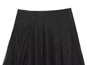 Detailed close-up of floral lace fabric and elastic waistband on a black midi skirt