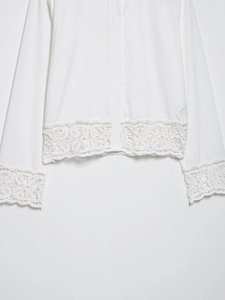 Détail d'une chemise blanche montrant l'ourlet en dentelle crochetée et les finitions