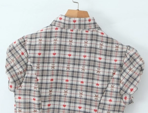 Detailed back view of plaid shirt with red hearts and bear print on wooden hanger