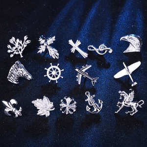 Macro view of fifteen mini silver metal pins featuring nature, animals, and symbols
