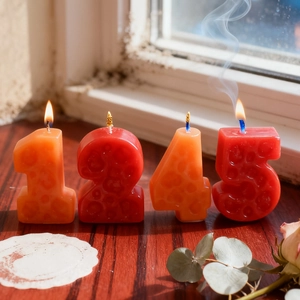Candele a forma di numeri rosse e arancioni con trama a nido d'ape per torte di compleanno
