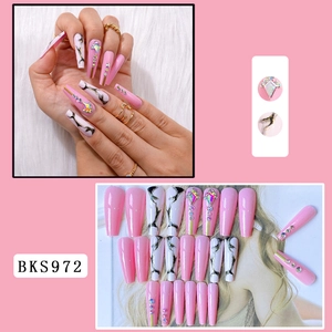 Macro detail of long coffin nails with pink marble design and rhinestone accents