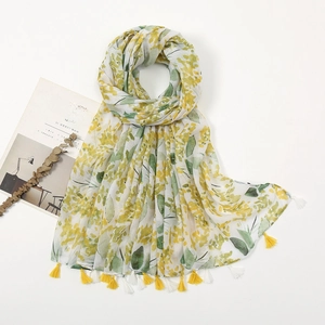 Detail of floral print scarf with soft yellow petals and elegant tassel fringe edge