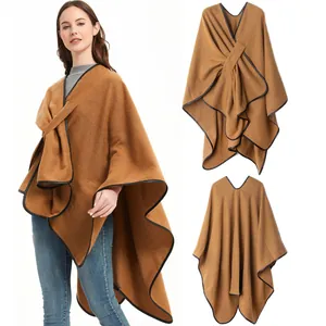 Detail of camel knit shawl with black leather trim and decorative metal buckle closure