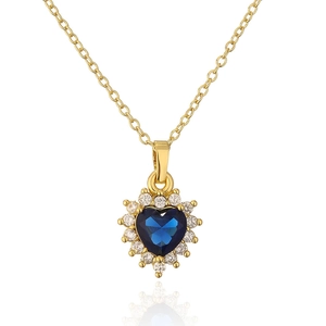 Detail of 18K gold heart pendant with blue gemstone and micro-pave zircon crystals