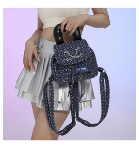 Detail of dark blue sequin mini backpack with chain strap held by a model