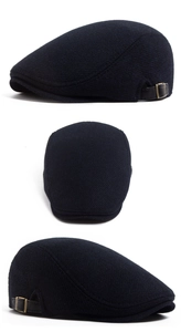 Detail of navy blue plaid flat cap with leather strap and bronze metal buckle