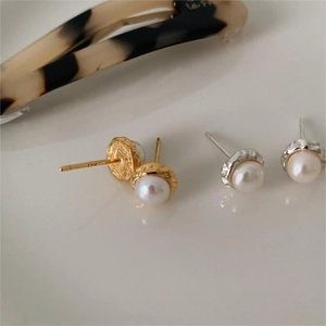 Macro detail of S925 sterling silver stamp on minimalist gold and silver pearl earrings